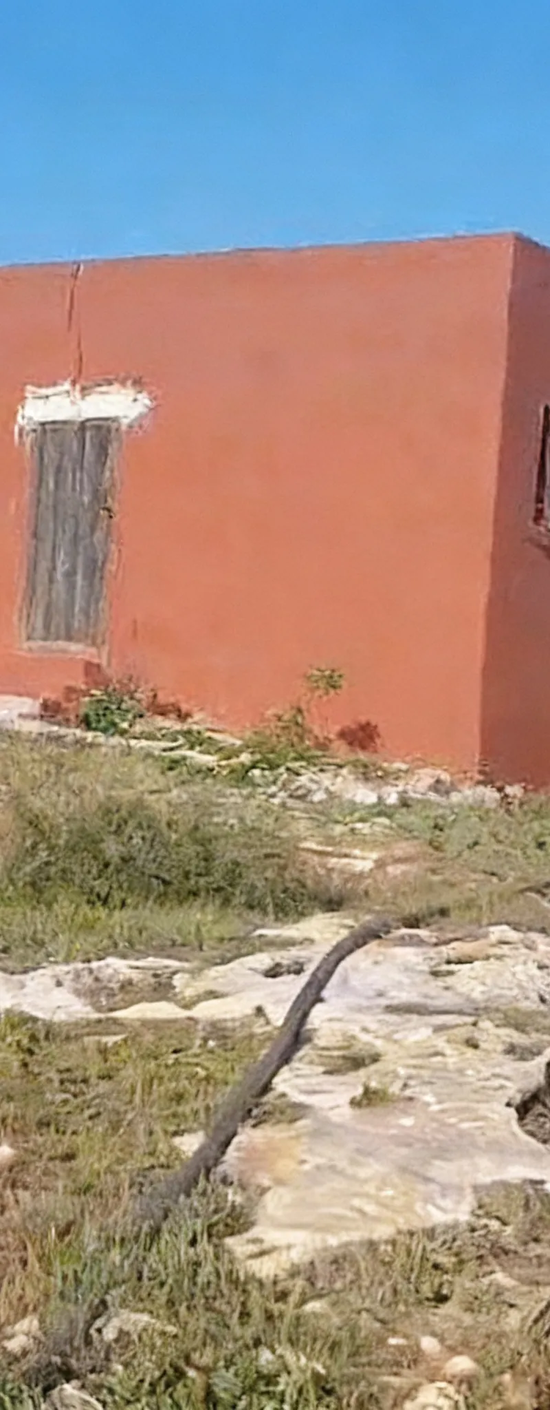 Terrain avec une maison équipée d'électricité et un puits avec pompe